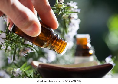 pour rosemary essential oil in a bowl - Shutterstock ID 549749782