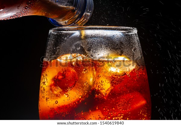 Pour\
soft drink in glass with ice splash on dark background,Castillo De\
Coca, Soda, Cola, Pouring, CarbonatedมSoft drink being poured into\
glassมSoda, Cola, Drink, Drinking Glass,\
Carbonated