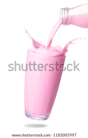 Pour strawberry milk from bottle into glass with splashing isolated on white background.
