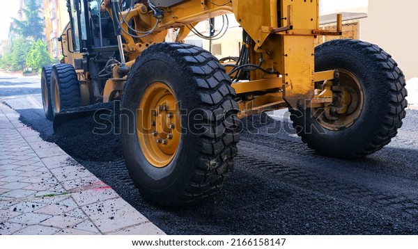 Pouring asphalt. asphalt work. Straighten the path\
with the roller tool.