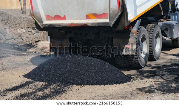 Pouring asphalt. asphalt work. Straighten the path
with the roller tool.