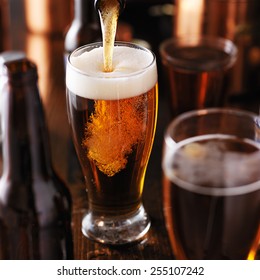 Pouring Beer Into Glass On Wooden Table