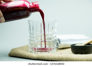 Pouring beetroot juice mix with ginger and lemon from bottle. Drink for colon cleansing - Powered by Shutterstock