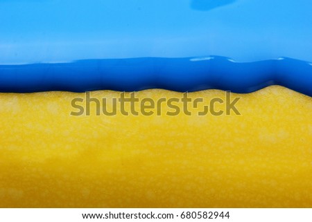 Pouring blue paint over yellow background, macro closeup.Texture.Abstract