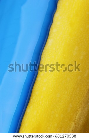 Pouring blue paint over yellow background, macro closeup.Texture.Abstract