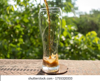 Pouring Brown Ale Beer In A Specific Beer Glass In The Yard. 