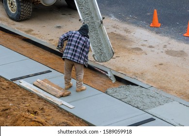 Pouring Cement In Process Of Pouring Concrete Into Newly Paved Sidewalk