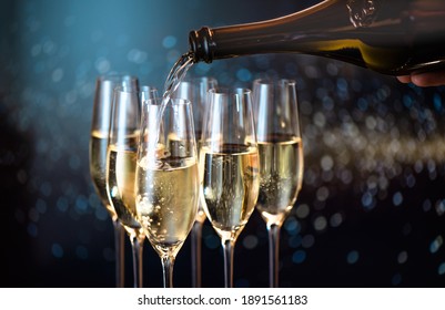 pouring champagne for a toast in a celebratory atmosphere with glasses of champagne  on golden flakes bokeh  background
