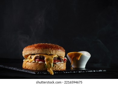 Pouring Cheese Sauce On A Lamb Burger  Black Back Ground 