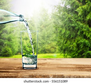 Pouring Clear Water Into Glass On Nature Background