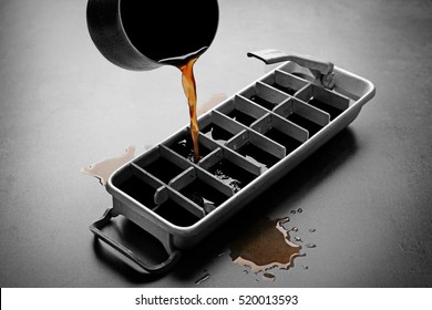 Pouring Coffee In Ice Cube Tray On Grey Background