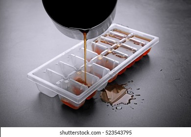 Pouring Coffee In Ice Cube Tray On Grey Background