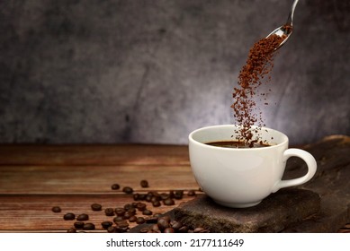pouring coffee powder on coffee cup on grey background - Shutterstock ID 2177111649