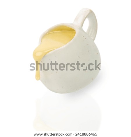 Pouring condensed milk in the jar isolated on white background,