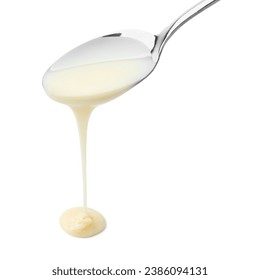 Pouring condensed milk from metal spoon isolated on white - Powered by Shutterstock