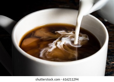 Pouring Cream into a Cup of Coffee - Shutterstock ID 616211294