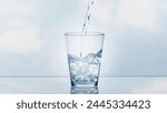 pouring drinking water in a transparent glass isolated on abstract background with glass table, water resource concept with copy space