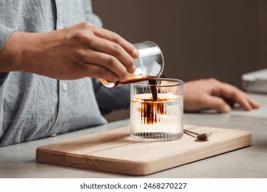 Pouring Espresso Into Glass of Ice for Making Ice Americano on Warm Day, Close-up - Powered by Shutterstock