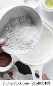 Pouring flour into a sieve, sifting flour for baking - Shutterstock ID 2254838183