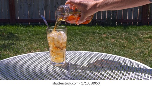 Pouring Fresh Brewed Sun Tea Or Sweet Tea From A Mason Jar Into A Glass Filled With Ice Cubes