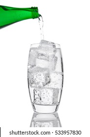 Pouring Fresh Sparkling Water From Bottle To Glass On White Background