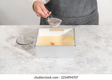 Pouring fudge mixture into the square cheesecake pan lined with parchment paper to prepare eggnog fudge. - Shutterstock ID 2254994707