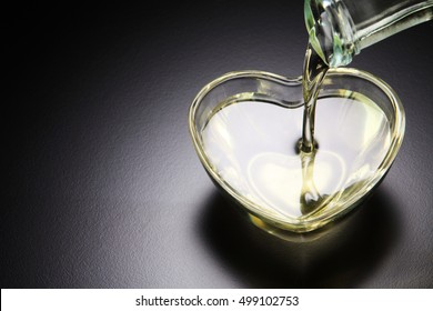 pouring grape seed oil into heart shape container
