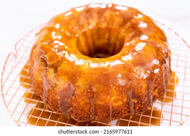 Pouring Homemade Caramel Glaze Over Freshly Baked Apple Bundt Cake.