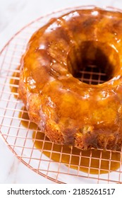 Pouring Homemade Caramel Glaze Over Freshly Baked Apple Bundt Cake.