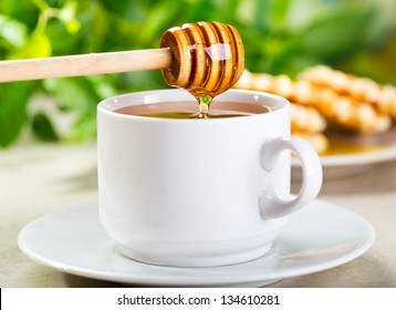 Pouring Honey Into Cup Of Tea