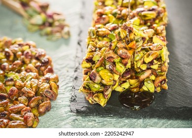 Pouring honey on traditional sugar coated pistachio sweets. Egyptian oriental dessert usually eaten during "Prophet Muhammad Birthday Celebration". - Shutterstock ID 2205242947
