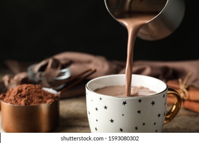 Pouring Hot Cocoa Drink Into Cup On Wooden Table