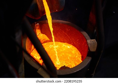 Pouring Hot Melted Metal Into Large Bucket In Furnace