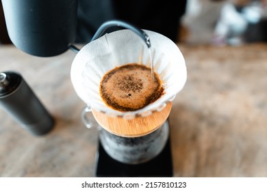 Pouring hot water in the kettle into the coffee. - Shutterstock ID 2157810123