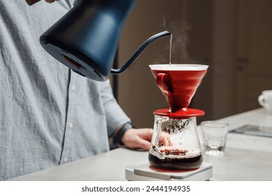 Pouring Hot Water From Kettle Into Red Coffee Funnel Over Glass Carafe On Scale Close-up - Powered by Shutterstock