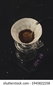 pouring a hot water over V60 coffee in filter to make a steaming pot of coffee - Shutterstock ID 1945822258