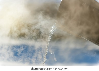 Pouring Hot Water In Winter At Sunset