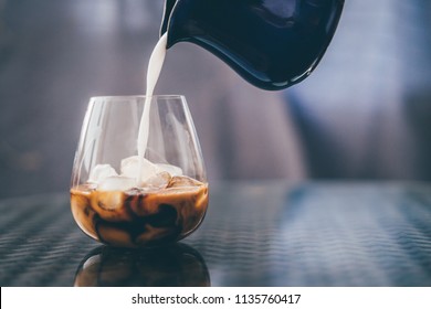 Pouring ice latte coffe in transparent glass