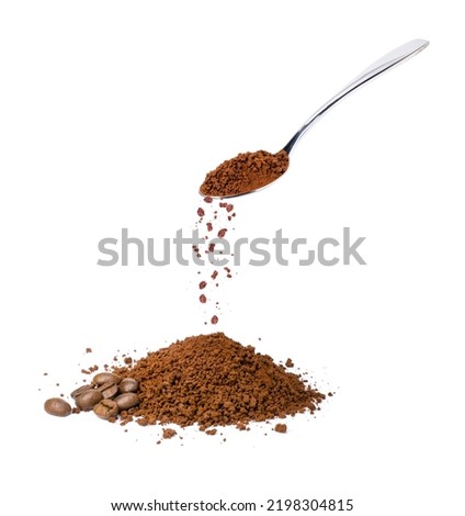 Pouring instant coffee or coffe powder from stainless teaspoon isolated on white background.