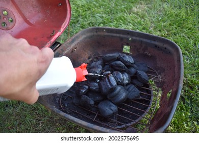 Pouring Lighter Fluid On A Barbeque Grill