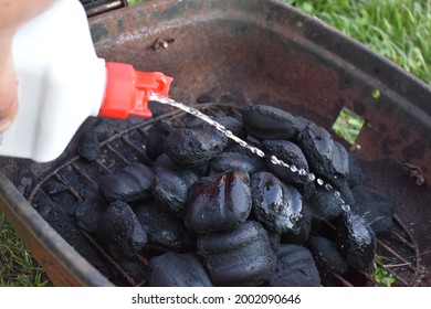 Pouring Lighter Fluid On Charcoal Briquettes