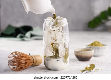 Pouring Matcha Tea Into Tall Boba Tea Glass With Ice And Milk To Make Matcha Latte