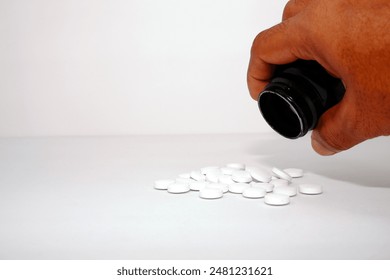 Pouring medicine pills with white background close-up view copy space  - Powered by Shutterstock