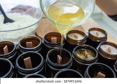Pouring melted wax. Handmade soy candles with mica and wooden wick. Amber and opaque container. Vegan product without animal cruelty. - Shutterstock ID 1874911696