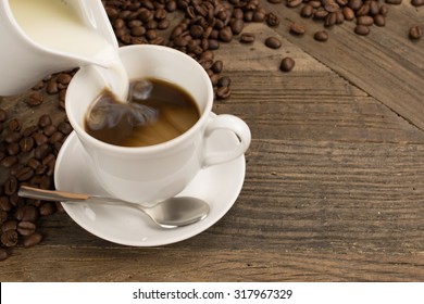 Pouring Milk In A Cup Of Coffee. 