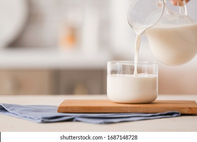 Pouring Of Milk Into Glass On Table