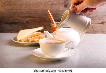 Pouring Milk Into White Cup Of Tea