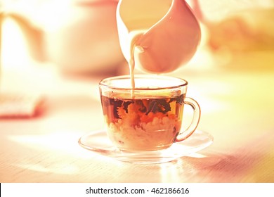 Pouring Milk In Tea On Table