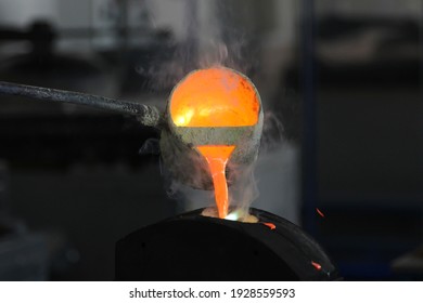 Pouring molten metal at the factory. Metallurgy concept, metal smelting. Being poured from the crucible into the mold.