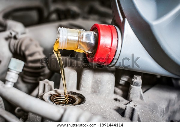 Pouring new\
engine oil into the car engine.\
Close-up